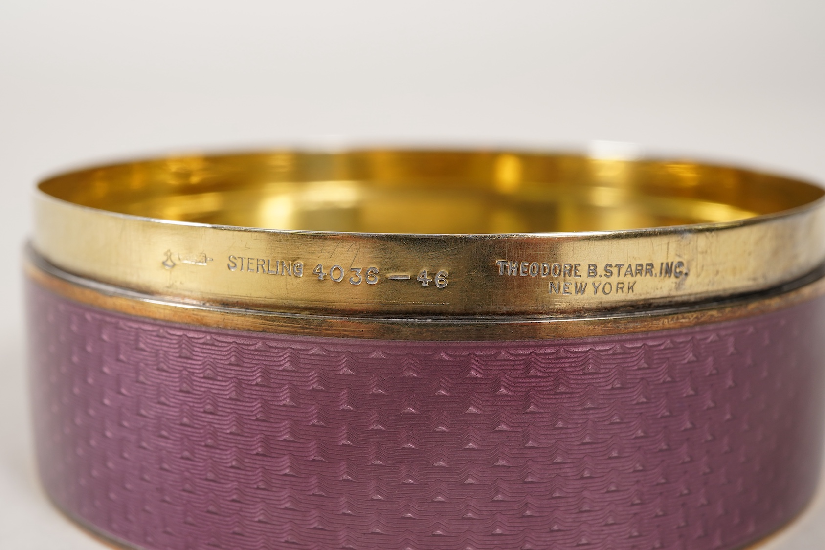 A late 19th/early 20th century North American sterling and mauve guilloche enamel circular box and cover, by Theodore B. Starr Inc, New York